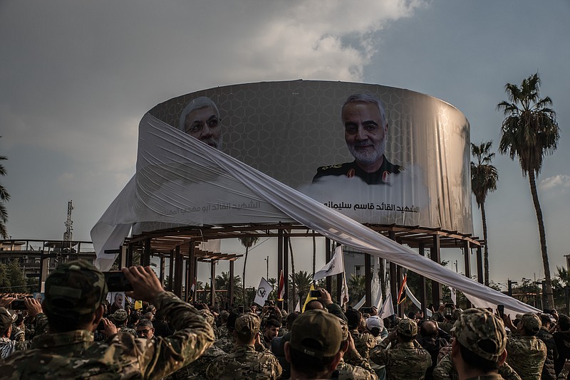 Members of the Hashd al-Shaabi militias watch as photos featuring Qasem Soleimani and Abu Mahdi al-Muhandis are unveiled in Karrada, Baghdad, on Jan. 20, 2020. MUST CREDIT: photo for The Washington Post by Emilienne Malfatto.