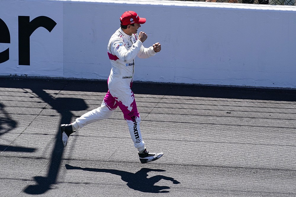 Helio Castroneves, of Brazil, runs down the track as he celebrates after winning the Indianapolis 500 auto race at Indianapolis Motor Speedway in Indianapolis, Sunday, May 30, 2021. (AP Photo/Darron Cummings)