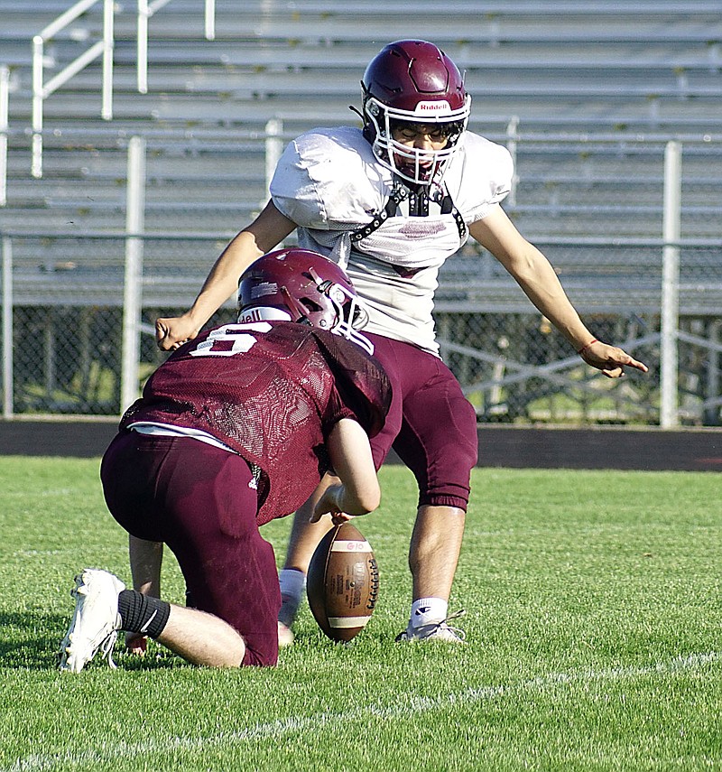 Westside Eagle Observer/RANDY MOLL
Ty Hays holds the ball for Gentry kicker Diego Saldana during the spring football game on Friday night. Saldana was 100 percent on his PATs and field goals for the evening.