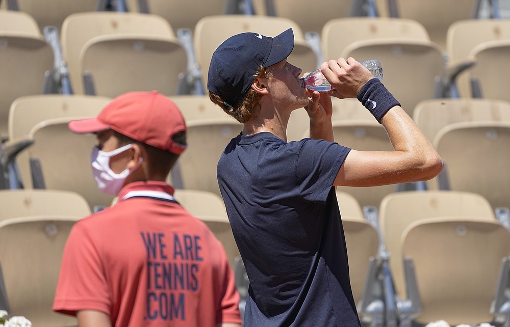 Italy's Jannik Sinner takes a drink during his match against Pierre-Hugues Herbert of France during their first round match on day two of the French Open tennis tournament at Roland Garros in Paris, France, Monday, May 31, 2021. (AP Photo/Michel Euler)