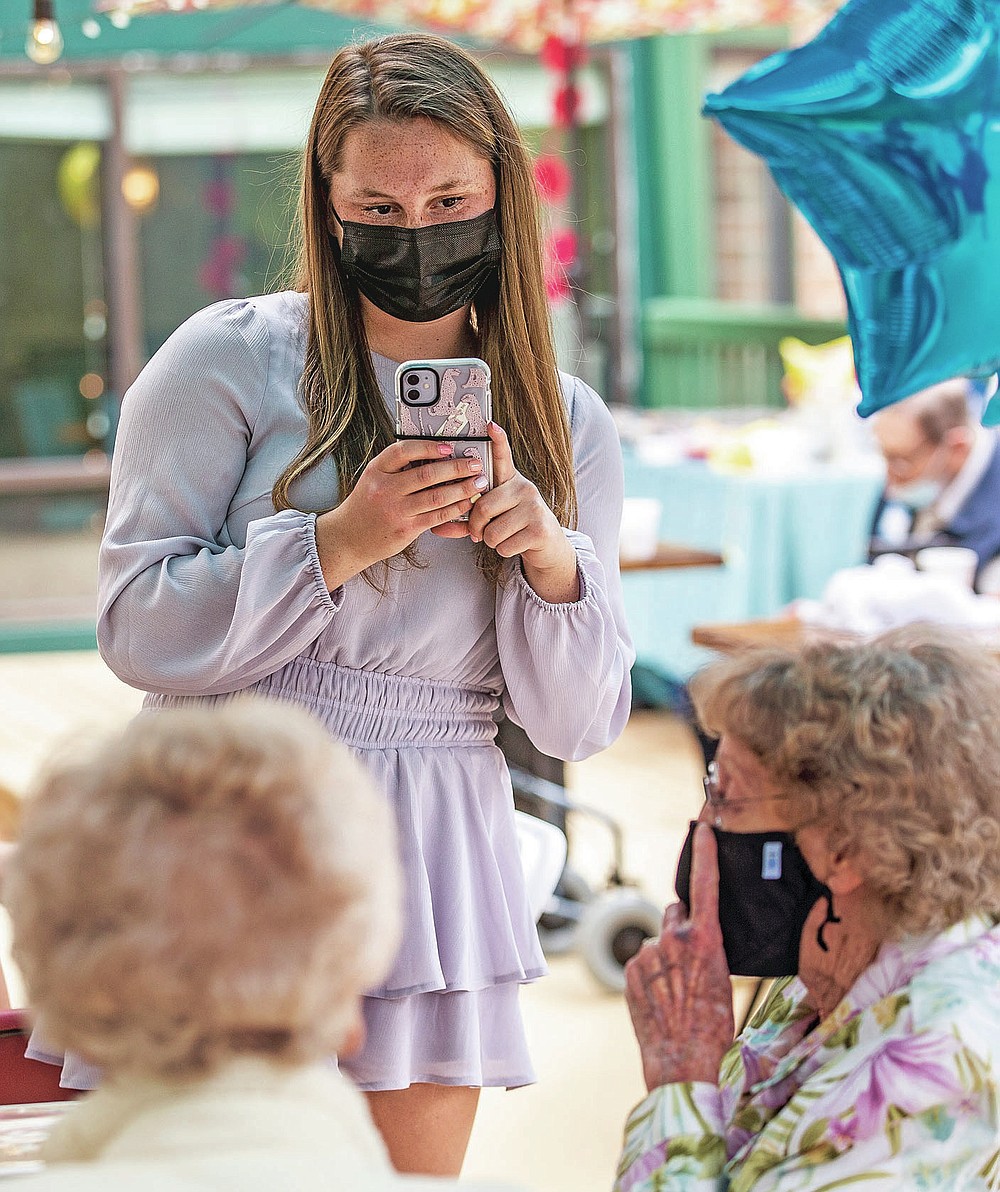 Sidney Smith makes a photo of pen pals at a reception for the Grimsley Pen Pal Club at Heritage Greens Senior Living in Greensboro, N.C., on Sunday, May 16, 2021. Smith founded the Penpal Club at Grimsley. (Woody Marshall/News & Record via AP)