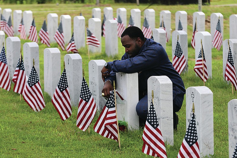 Gold Star Family member Sean Daniels of Conway kneels at the grave of his brother, Sgt. Jamar Hicks, who was killed in Afghanistan in Aug. 2013, after the State Memorial Day Program on Monday, May 31, 2021, at the Arkansas State Veterans Cemetery at North Little Rock. Daniels gave the benediction during the Memorial Day Program. 
More photos at www.arkansasonline.com/61memorial/
(Arkansas Democrat-Gazette/Thomas Metthe)