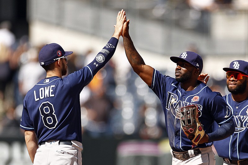 Tampa Bay Rays left fielder Randy Arozarena high-fives second baseman Brandon Lowe (8) after defeating the New York Yankees in a baseball game on Monday, May 31, 2021, in New York. The Rays won 3-1. (AP Photo/Adam Hunger)