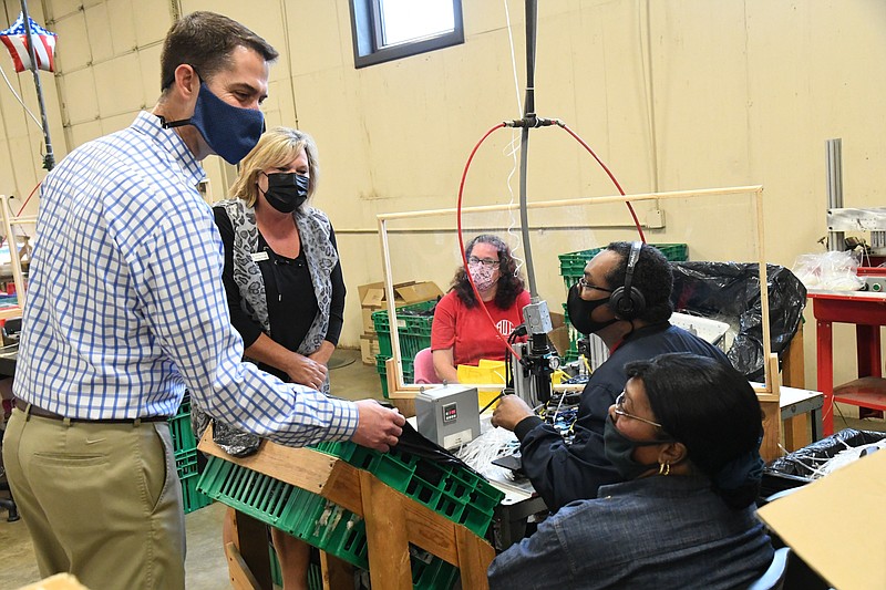 U.S. Sen. Tom Cotton, R-Ark., left, meets with workers at Abilities Unlimited Inc. during a visit to the facility on Tuesday.  - Photo by Tanner Newton of The Sentinel-Record