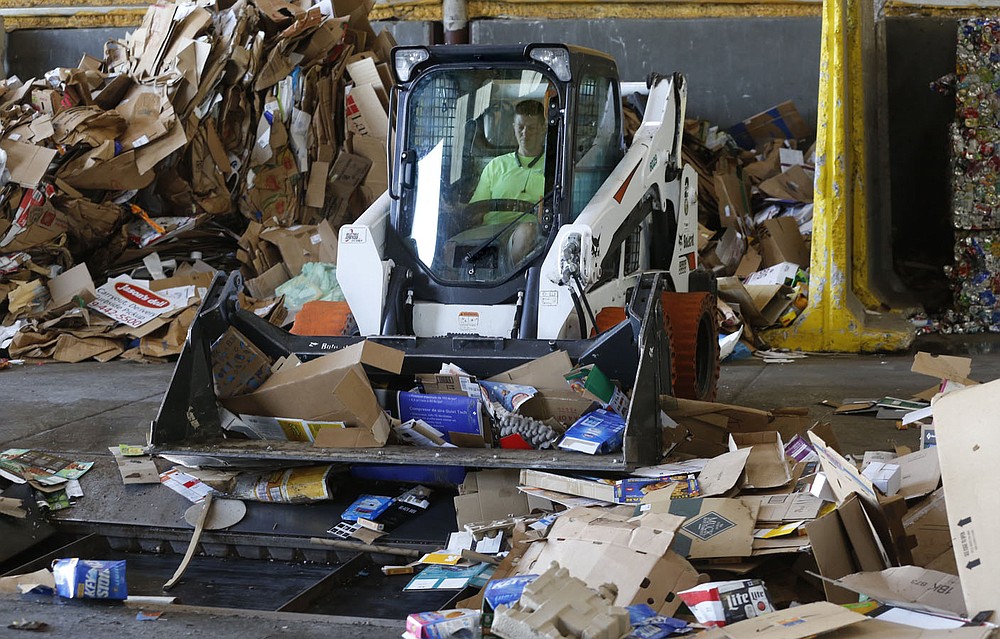 Magan (cq) Osburn, a driver, drives a Bobcat skid steer Friday, June 11, 2021, to distribute cardboard at the Material Recovery Facility for the Recycling and Trash Collection Division for the city. The Northwest Arkansas Council is proposing a circular economy that makes use of regional recycling programs to create new businesses and jobs and reduce waste. Check out nwadg.com/photos for a photo gallery.
(NWA Democrat-Gazette/David Gottschalk)