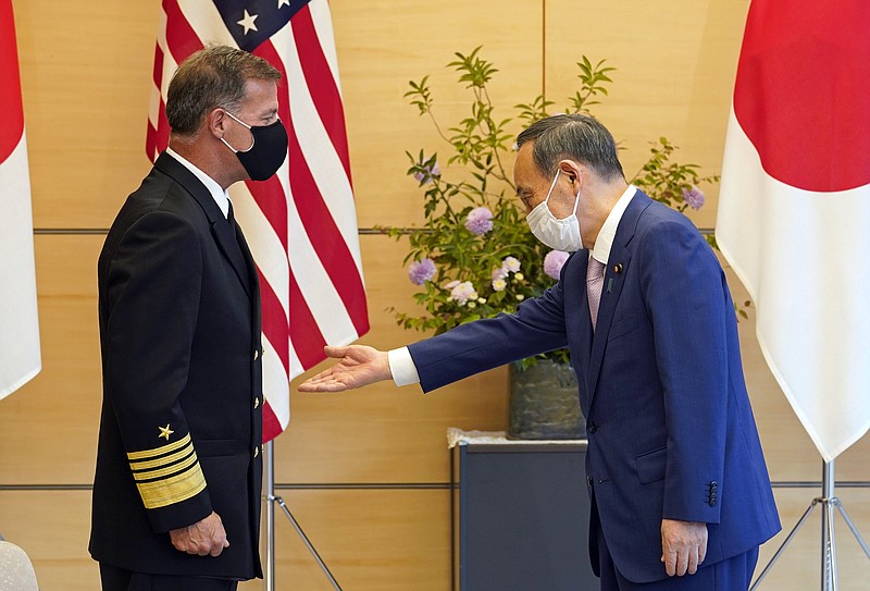 Admiral John C. Aquilino, left, Commander of the United States Indo-Pacific Command, is welcomed by Japanese Prime Minister Yoshihide Suga at the start of their meeting at the prime minister's official residence in Tokyo, Japan, Tuesday, June 1, 2021. (Franck Robichon/Pool Photo via AP)