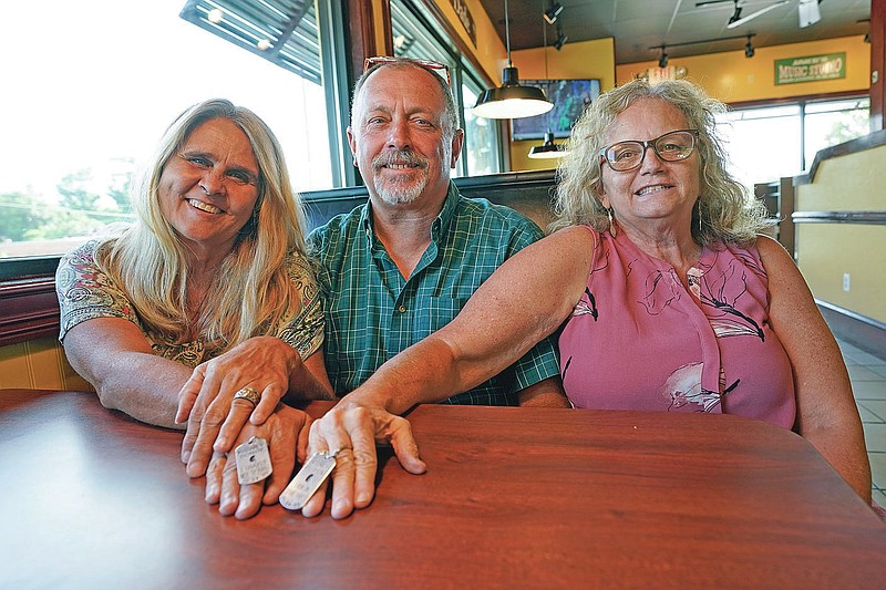 CORRECTS ID TO JIM MERTHE NOT JIM STRICKLAND Two days after Debby-Neal Strickland, left, and Jim Merthe, center, were married in November, Debby donated a kidney to Jim's ex-wife Mylaen Merthe, right, as they show off donor/recipient tags they had made during a get together Tuesday, May 25, 2021, at a restaurant in Ocala, Fla. (AP Photo/John Raoux)