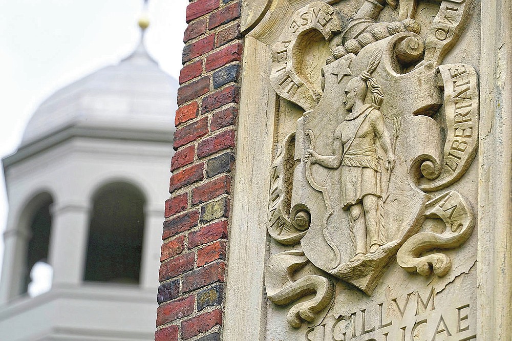 An image of a Native American, right, is featured in the artwork of Johnston Gate, Harvard University's first and largest gate heading to the campus, in Cambridge, Mass., Sunday, May 23, 2021. Some 350 years ago, Caleb Cheeshahteaumuck, an Aquinnah Wampanoag man, became the first Native American to graduate from the university, the product of Harvard's chartered mission to educate "English and Indian youths of this country." (AP Photo/Steven Senne)