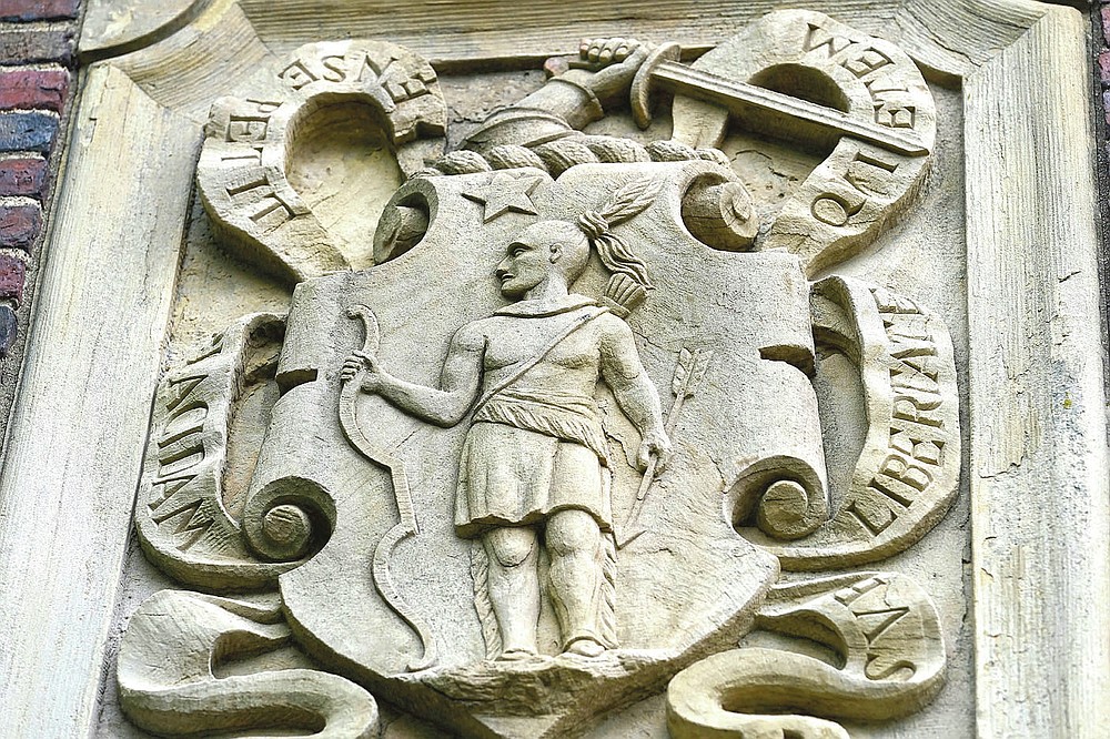 An image of a Native American is featured in the artwork of Johnston Gate, Harvard University's first and largest gate heading to the campus, in Cambridge, Mass., Sunday, May 23, 2021. Some 350 years ago, Caleb Cheeshahteaumuck, an Aquinnah Wampanoag man, became the first Native American to graduate from the university, the product of Harvard's chartered mission to educate "English and Indian youths of this country." (AP Photo/Steven Senne)