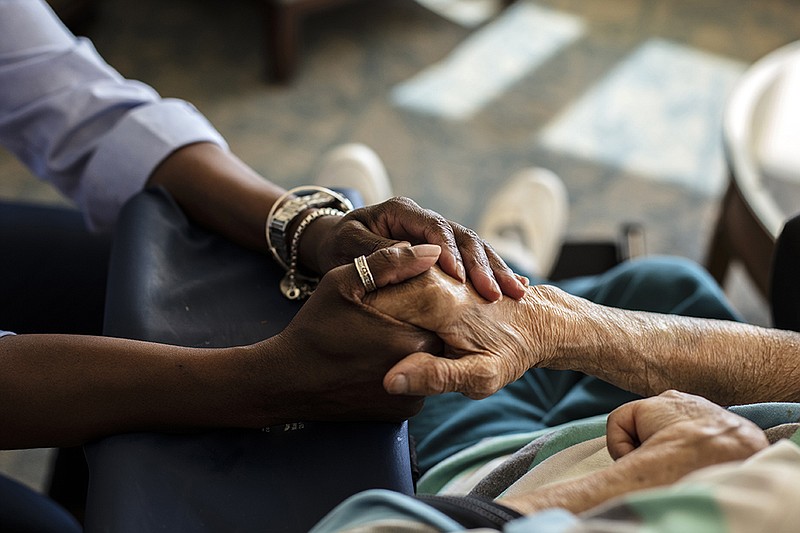 Marcelle Doherty, left, holds hands with her mother Gladys Pieters at Reformed Church Home in Old Bridge, N.J., on Monday, March 29, 2021. It was their first visit where they could do this since the coronavirus pandemic began last year. (Bryan Anselm/The New York Times)
