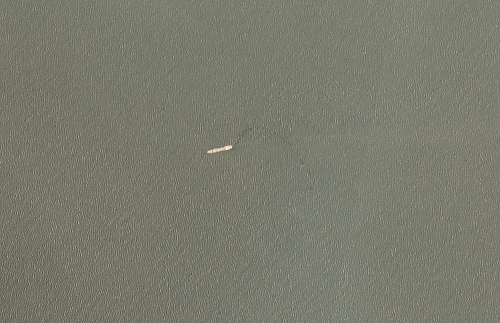 In this satellite image provided by Planet Labs Inc. the Iranian navy's Kharg support ship is seen off the coast of Jask, Iran, Tuesday, June 1, 2021. The Kharg, the largest ship in the Iranian navy, caught fire and later sank Wednesday, June 2, 2021 in the Gulf of Oman under unclear circumstances, semiofficial news agencies reported. (Planet Labs Inc. via AP)