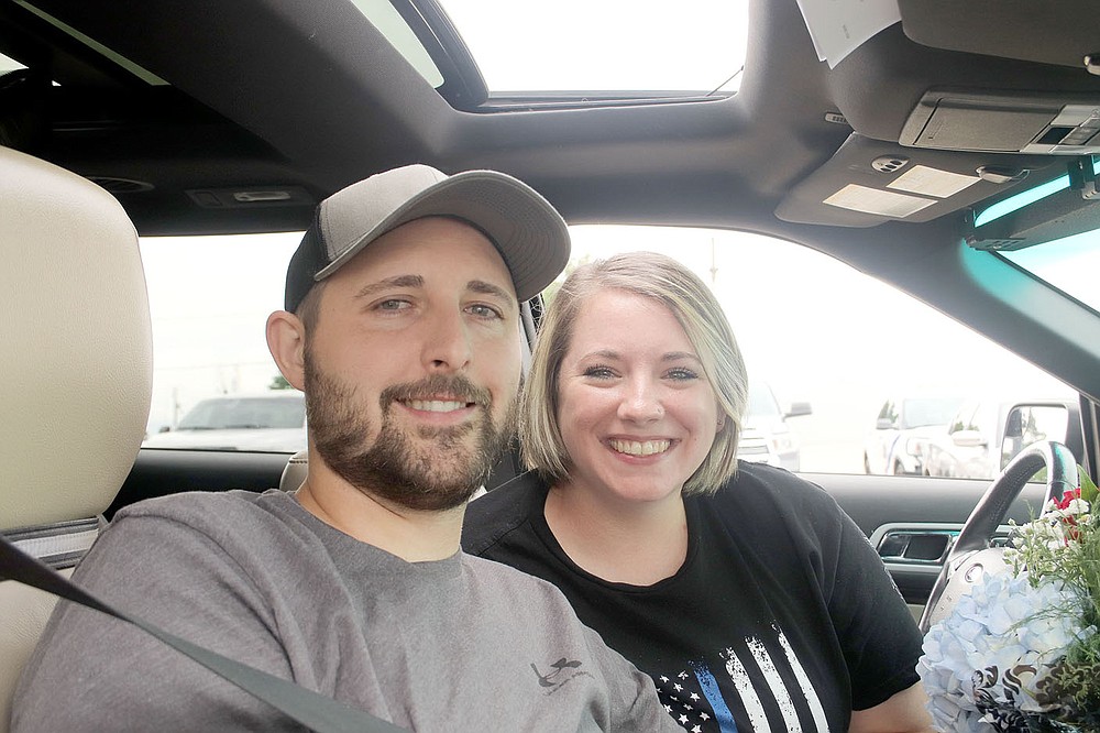 LYNN KUTTER ENTERPRISE-LEADER
Prairie Grove Police Officer Tyler Franks and his wife, Amber, meet with the media, friends, family and the community in the library parking lot following a "Welcome Home" parade in his honor on June 2.