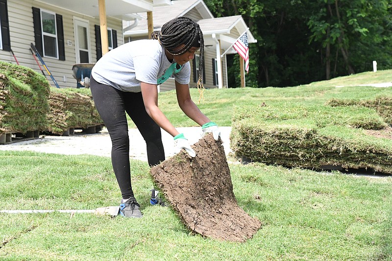 Geah King, daughter of new homeowner Renee Osborn, lays sod at their Habitat home at 226 Eddiemee St. Habitat will dedicate 222 and 226 Eddiemee on Saturday. - Photo by Tanner Newton of The Sentinel-Record