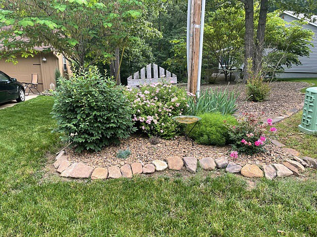 Photo submitted There is a beautiful side yard with plenty of trees forming a beautiful oasis with a bench.
