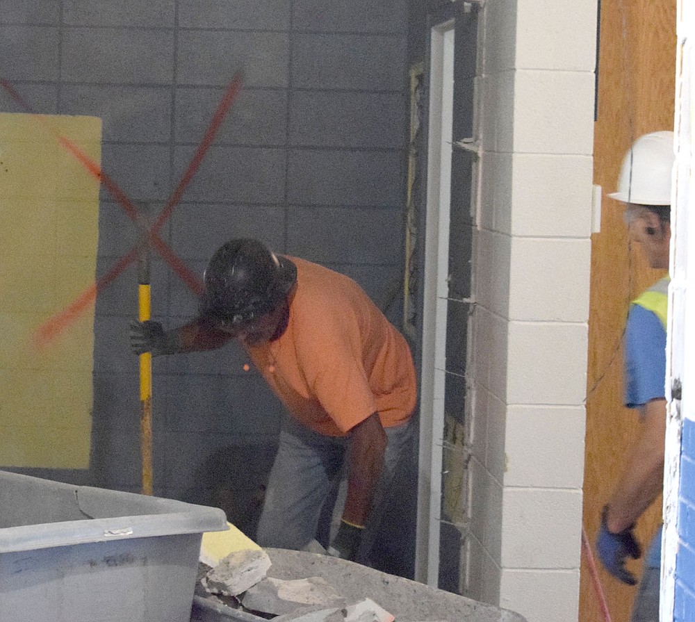 Westside Eagle Observer/MIKE ECKELS
A worker loads up a wheelbarrow with concrete blocks which were once part of the Home Economics classroom Thursday morning at Decatur High School. Work on phase two of the high school renovation began in late April and will continue through the summer.