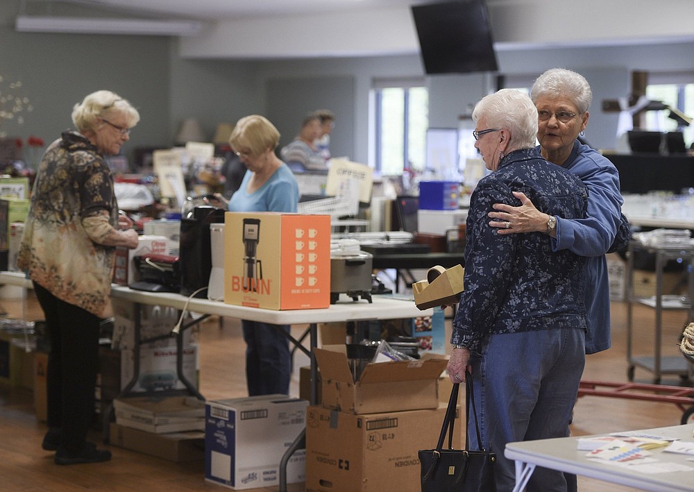 NWA Democrat-Gazette/CHARLIE KAIJO Suzanne Evans of Bella Vista (right) greets Glenda Redenius of Bella Vista during the setup of a flea market, Thursday, April 25, 2019 at Highlands Church of Bella Vista in Bella Vista.
The church is having their 25th annual flea market. All of the market's proceeds will go to benefit Benton County charities including the NWA Children’s Shelter, the NWA Women’s Shelter and Samaritan’s feet to name a few.
