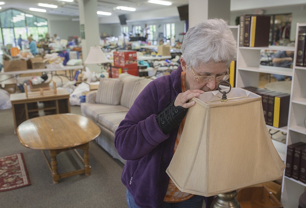 NWA Democrat-Gazette/CHARLIE KAIJO Patricia Lehman of Bella Vista changes the bulb of a lamp for sale during the setup of a flea market, Thursday, April 25, 2019 at Highlands Church of Bella Vista in Bella Vista.
The church is having their 25th annual flea market. All of the market's proceeds will go to benefit Benton County charities including the NWA Children’s Shelter, the NWA Women’s Shelter and Samaritan’s feet to name a few.