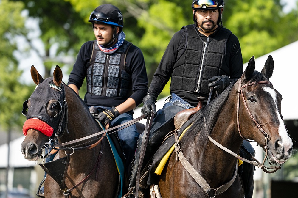 Belmont stakes entrant Hot Rod Charlie, left, and his companion horse Lava Man, right, are led to the main track for a training run ahead of the 153rd running of the Belmont Stakes horse race, Wednesday, June 2, 2021, at Belmont Park in Elmont, N.Y. (AP Photo/John Minchillo)