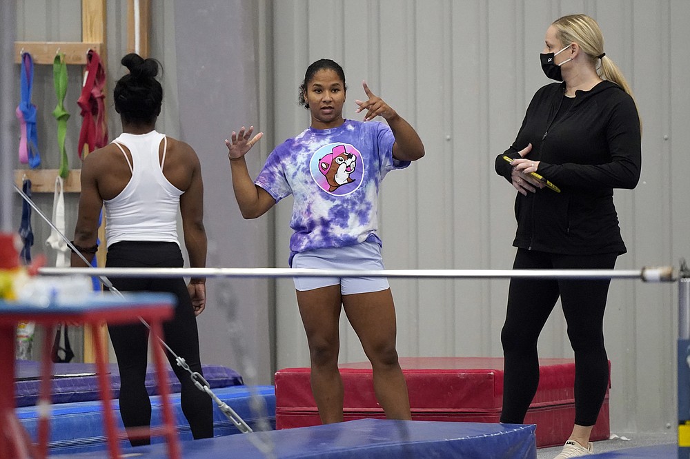 FILE - In this May 11, 2021, file photos, gymnast Jordan Chiles, center, talks with coach Cecile Landi, right and reigning Olympic champion gymnast Simone Biles, left, while training in Spring, Texas. The 20-year-old Chiles will compete at the U.S. Championships this weekend hoping to build off a strong performance at the U.S. Classic, where she finished second to Olympic and world champion Simone Biles. (AP Photo/David J. Phillip, File)