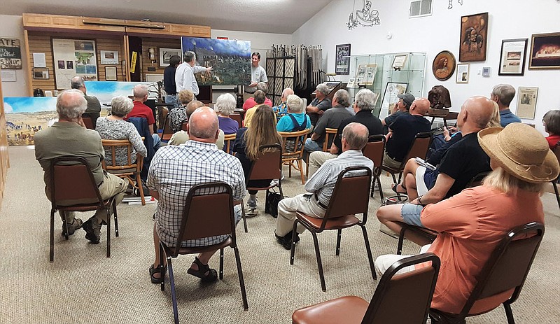 Photo courtesy of the Bella Vista Historical Museum Dan Hoffbauer explains to the Bella Vista Civil War Roundtable audience what was happening in his painting of the action around the Elkhorn Tavern.