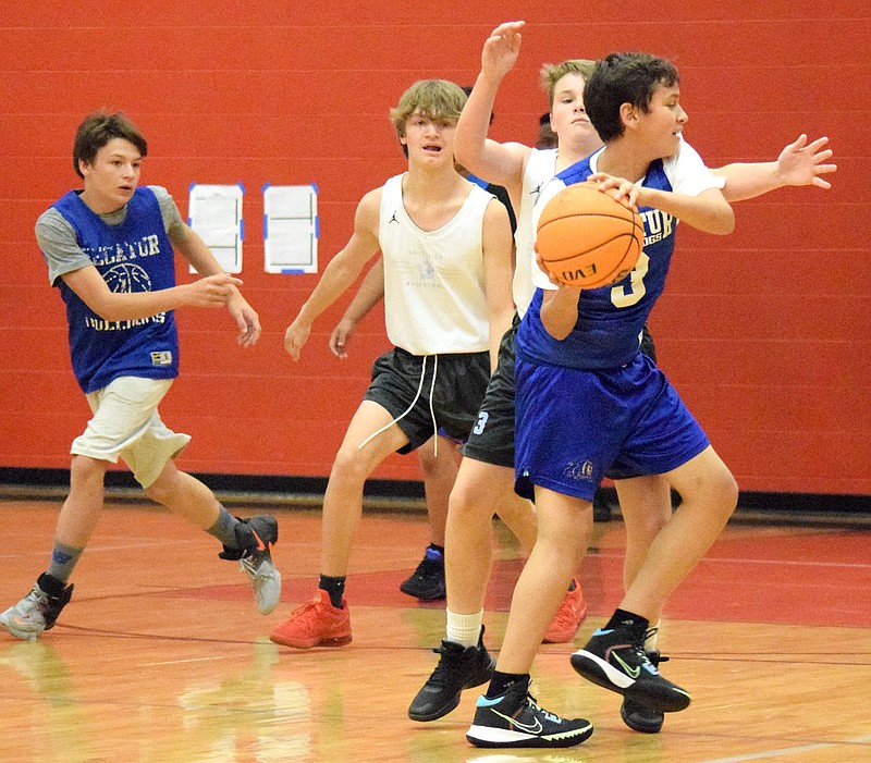 Westside Eagle Observer/MIKE ECKELS
Bulldog Giovani Puga (right) tries to drive around a Maverick defender as Jason Bruffett move in to help during the Decatur-Southside junior high team camp basketball game at the Arkansas Athletics Outreach facility in Fayetteville June 8. The Mavericks, a 6A conference team, defeated the Bulldogs 26-4.