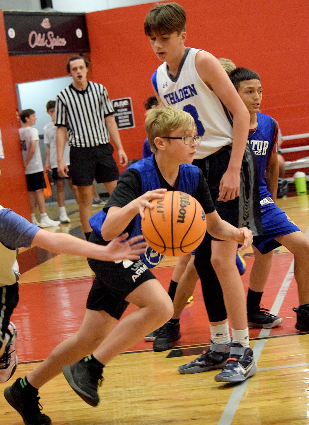Westside Eagle Observer/MIKE ECKELS
After pulling down a rebound, Devin Pembleton (center) drives toward the Bulldog net during the Decatur-Thaden junior high basketball contest on court number 2 at the Arkansas Athletics Outreach team camp in Fayetteville June 8. The junior high team took the 22 minute contest 21-17.