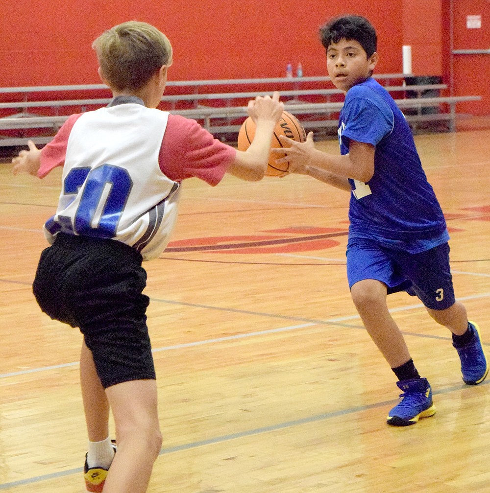 Westside Eagle Observer/MIKE ECKELS
John Colorado (right) looks for a teammate to pass the ball to during the second half of the Decatur-Thaden junior high basketball game in Fayetteville June 8. The Decatur boys participated in the 2021 Arkansas Athletics Outreach team camp where the team claimed the win 21-17.
