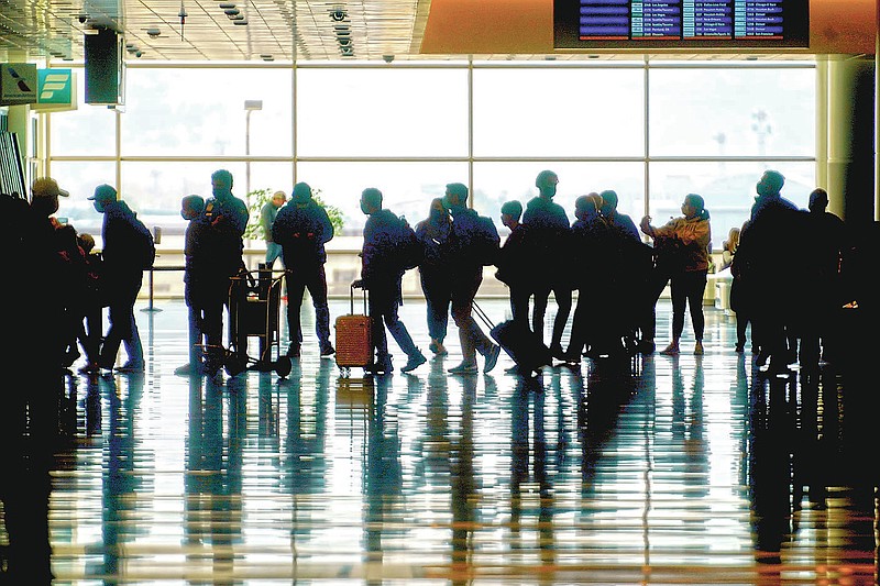 FILE - In this March 17, 2021 file photo, travelers walk through the Salt Lake City International Airport in Salt Lake City. On Friday, June 4, 2021, The Associated Press reported on stories circulating online incorrectly asserting that airlines recently met to discuss the risks and liability of carrying passengers vaccinated against COVID-19. (AP Photo/Rick Bowmer, File)