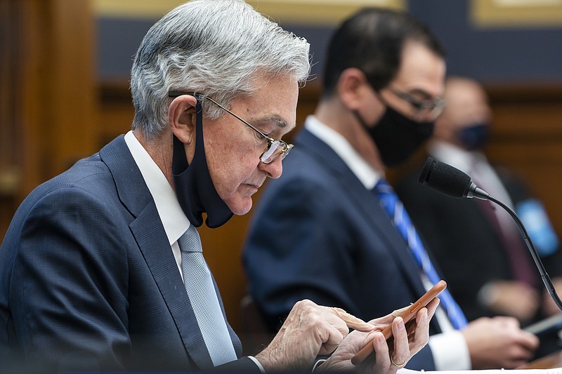 FILE - In this Dec. 2, 2020 file photo, Federal Reserve Chair Jerome Powell, left, arrives to testify before a House Financial Services Committee hearing on Capitol Hill in Washington.  Powell says, Friday, June 4, 2021,  the U.S. central bank is studying how climate change might affect banks. But the Fed doesn't see itself as getting involved in how to fight climate change.  (Jim Lo Scalzo/Pool via AP)