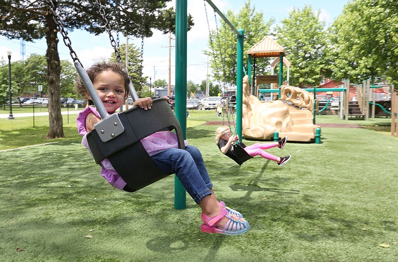 Kya Sierra, 1, swings May 29 on the playground at Dave Peel Park on East Central Avenue in downtown Bentonville. The Bentonville Downtown Quilt of Parks will receive $5 million from an April bond issue to do upgrades to Dave Peel Park and to build The Commons on an empty parking lot.
(File Photo/NWA Democrat-Gazette/David Gottschalk)