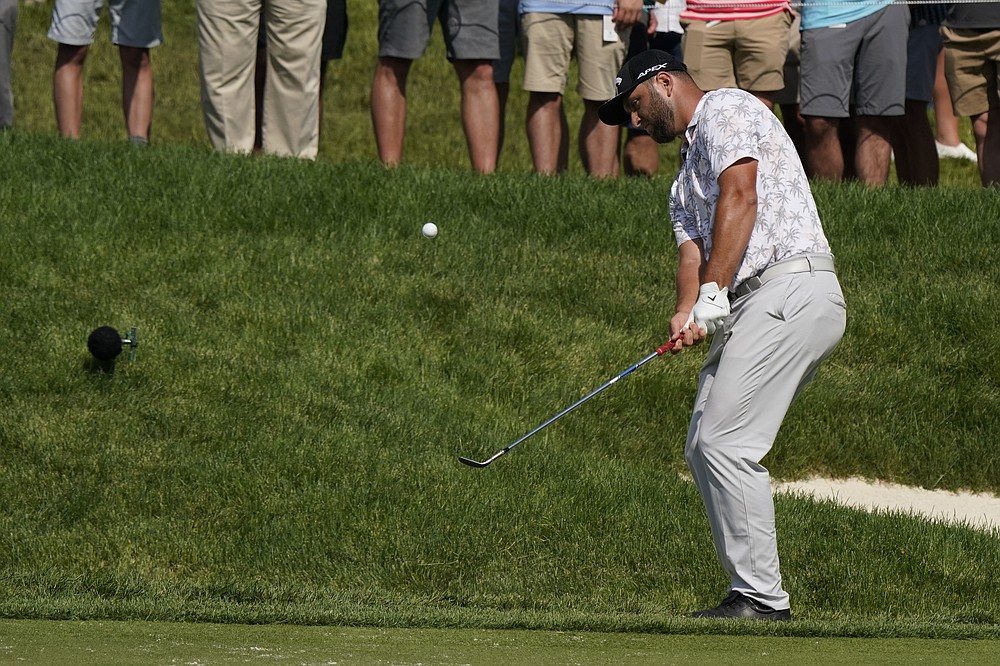 Jon Rahm chips to the 14th green during the third round of the Memorial golf tournament, Saturday, June 5, 2021, in Dublin, Ohio. Rahm was later notified he tested positive for the coronavirus, knocking him out of the tournament. (AP Photo/Darron Cummings)