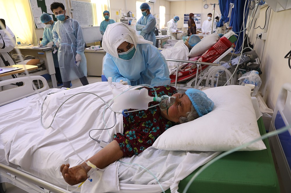 An Afghan doctor checks a COVID-19 patient at the Afghan-Japan Communicable Disease Hospital in Kabul, Afghanistan, Sunday, May 30, 2021. Afghanistan is battling a brutal third wave of COVID infections, while health officials plead for vaccines, expressing deep frustration at the inequities of the global vaccine distribution. Positive COVID cases jump from eight percent to 60 per cent in some parts of the country. (AP Photo/Rahmat Gul)