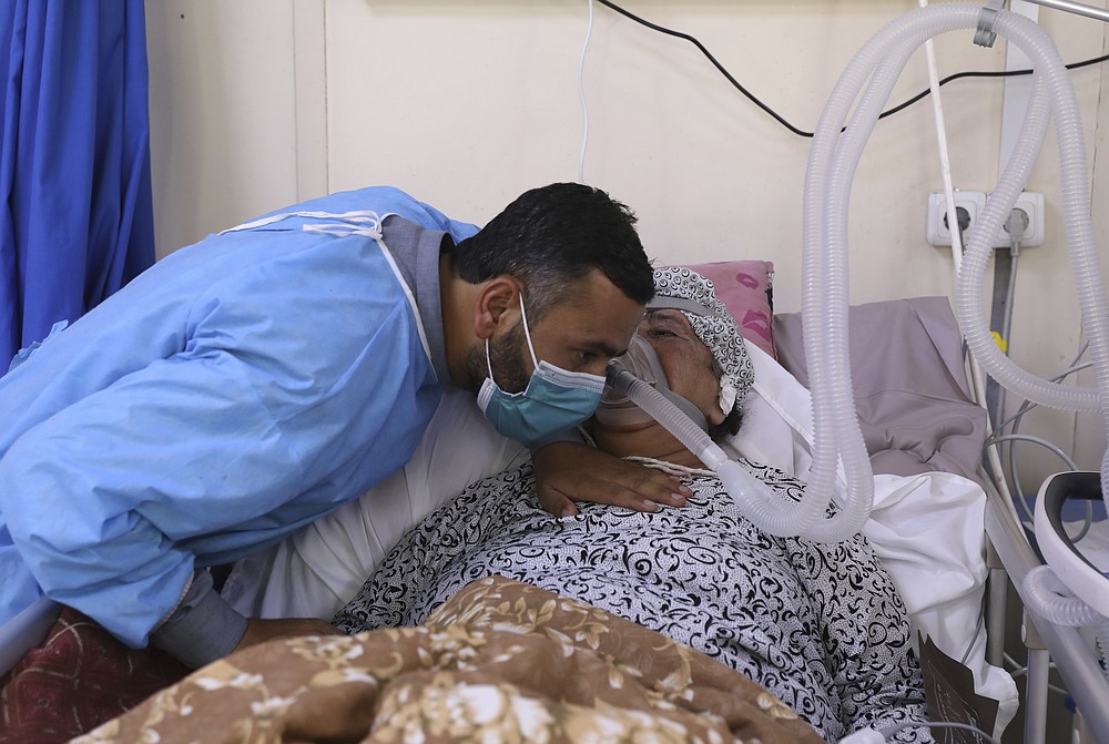 An Afghan man talks with his mother in the intensive care unit ward for COVID-19 patients at the Afghan-Japan Communicable Disease Hospital in Kabul, Afghanistan, Sunday, May 30, 2021. Afghanistan is battling a brutal third wave of COVID infections, while health officials plead for vaccines, expressing deep frustration at the inequities of the global vaccine distribution. Positive COVID cases jump from eight percent to 60 per cent in some parts of the country. (AP Photo/Rahmat Gul)