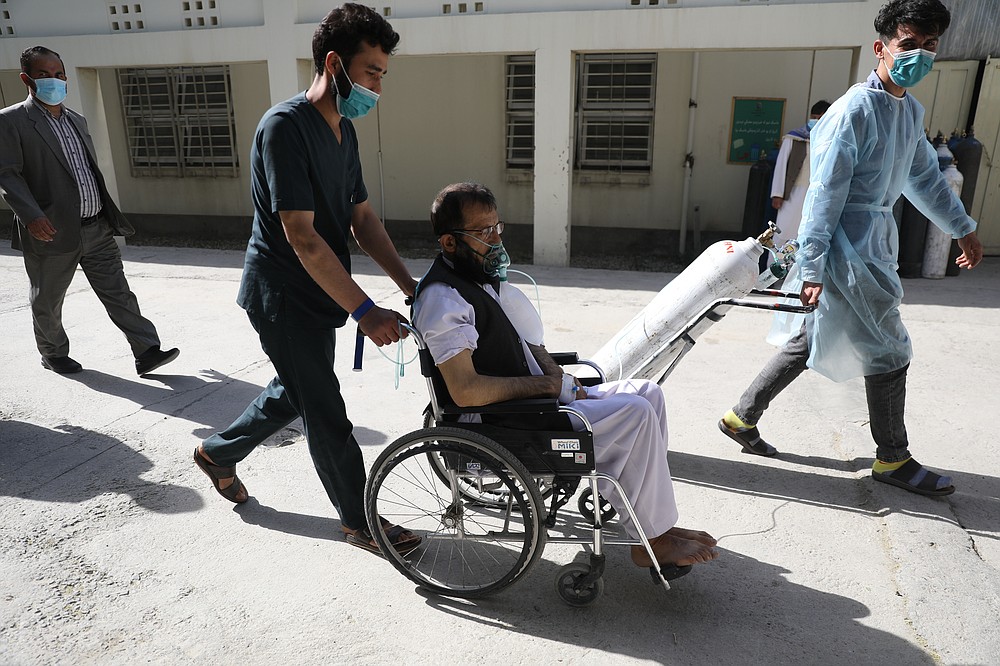 Afghan doctors wheel a patient breathing through an oxygen mask at the Afghan-Japan Communicable Disease Hospital to a special ward for COVID-19 patients, in Kabul, Afghanistan, Sunday, May 30, 2021. Afghanistan is battling a brutal third wave of COVID infections, while health officials plead for vaccines, expressing deep frustration at the inequities of the global vaccine distribution. Positive COVID cases jump from eight percent to 60 per cent in some parts of the country. (AP Photo/Rahmat Gul)