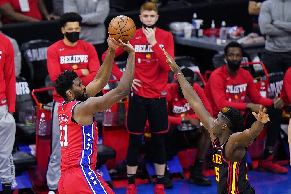 Philadelphia 76ers' Joel Embiid, left, goes up for shot against Atlanta Hawks' Clint Capela during the second half of Game 1 of a second-round NBA basketball playoff series, Sunday, June 6, 2021, in Philadelphia. (AP Photo/Matt Slocum)