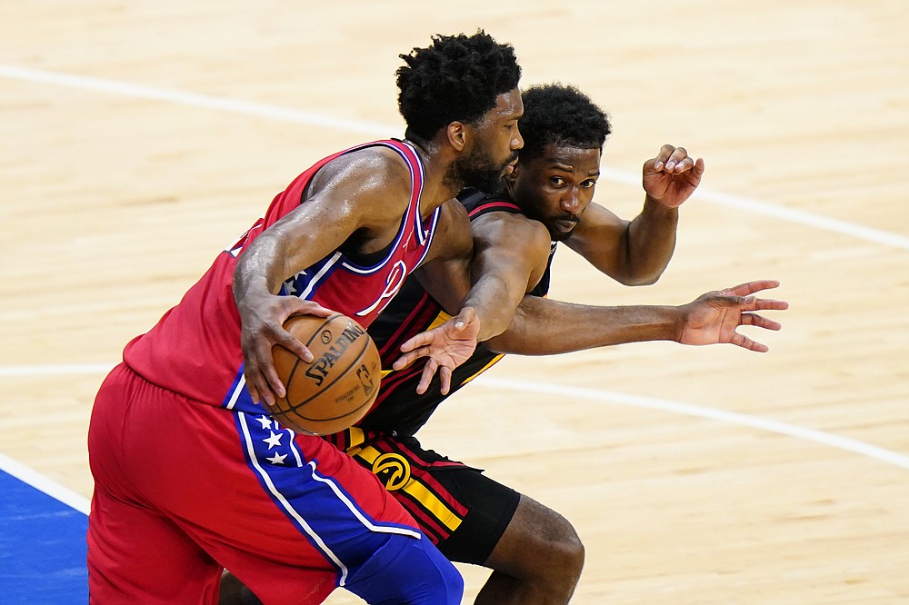 Atlanta Hawks' Solomon Hill, right, tries to get the ball away from Philadelphia 76ers' Joel Embiid during the second half of Game 1 of a second-round NBA basketball playoff series, Sunday, June 6, 2021, in Philadelphia. (AP Photo/Matt Slocum)
