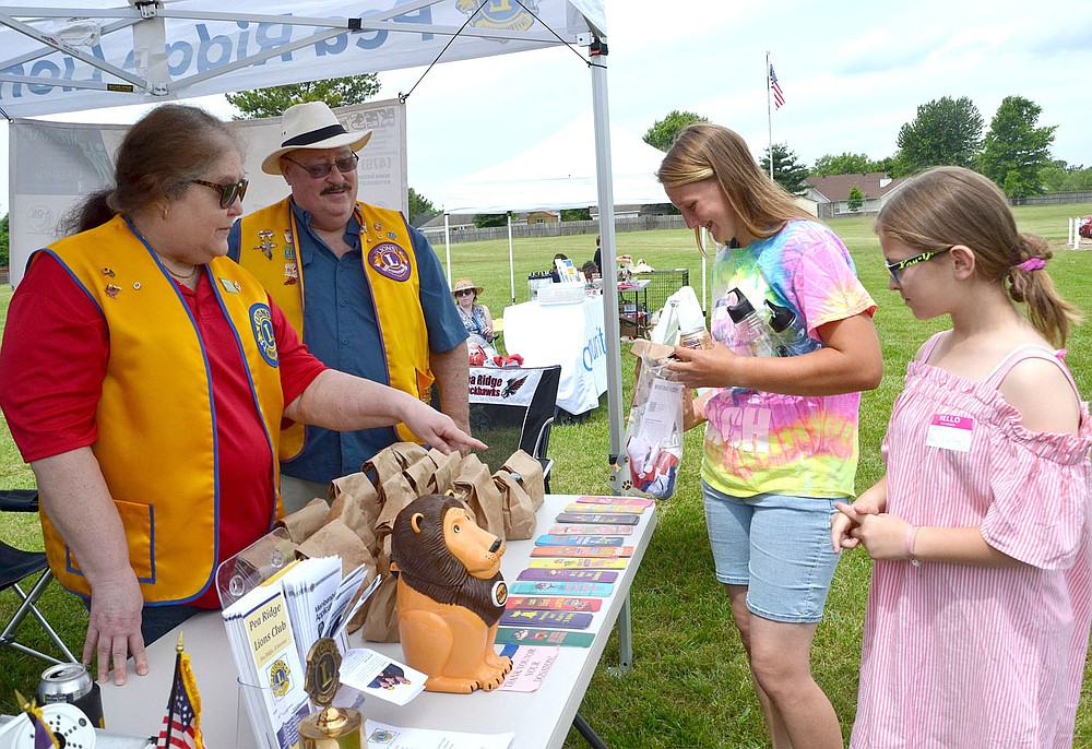 Members of the Pea Ridge Lions Club offer bookmarks to visitors at the Pea Ridge Library Summer Reading Kickoff bash Saturday, June 5.