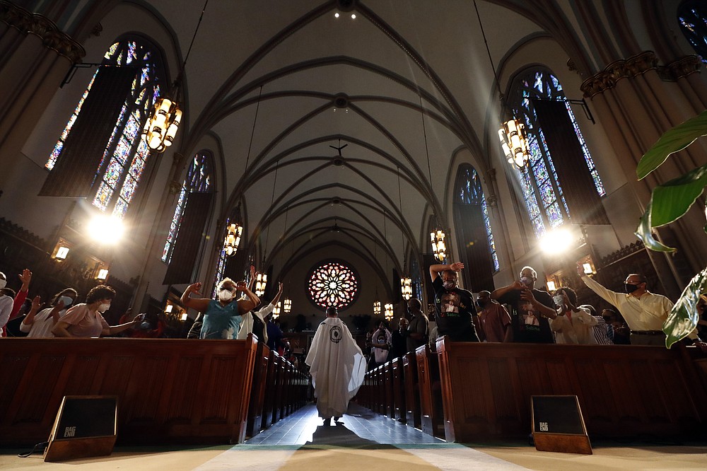 Rev. Michael Pfleger enters to conduct his first Sunday church service as a senior pastor at St. Sabina Catholic Church following his reinstatement by Archdiocese of Chicago after decades-old sexual abuse allegations against minors, Sunday, June 6, 2021, in the Auburn Gresham neighborhood in Chicago. (AP Photo/Shafkat Anowar)