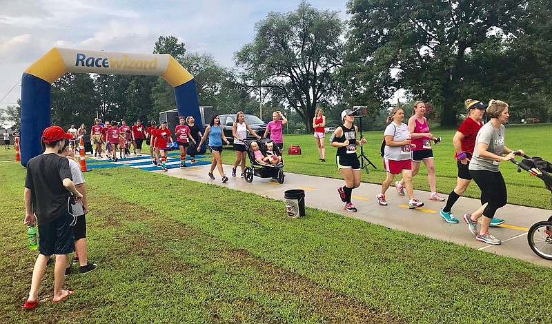 Photo by Mallory Weaver
A string of runners crosses the finish line in the 2019 Gravette Day 5K. More than 120 runners and walkers participated in the 2019 event. Registration is now open for this year's race, sponsored by the Gravette Gym, with all proceeds to benefit the Gravette Fire Department.