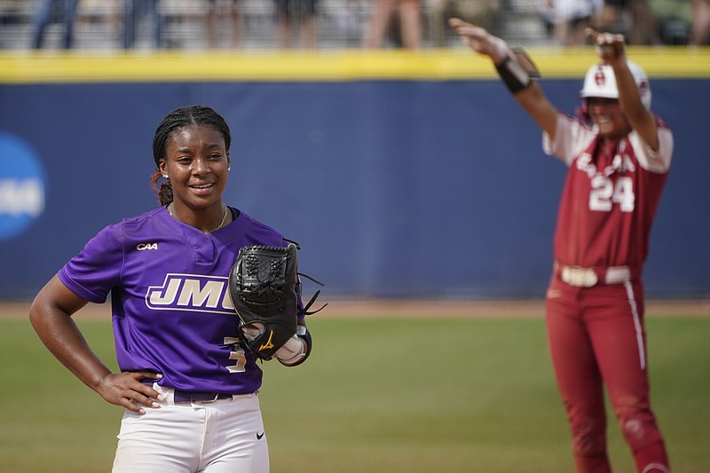 James Madison starting pitcher Odicci Alexander (3) stands in the pitching circle as Oklahoma's Jayda Coleman (24) celebrates at second base behind her after hitting a double in the fifth inning of an NCAA Women's College World Series softball game Monday, June 7, 2021, in Oklahoma City. (AP Photo/Sue Ogrocki)