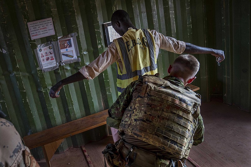 An Estonian Barkhane force soldier checks a Malian worker leaving the base after a day's work in Gao, eastern Mali, Sunday June 6, 2021. Col. Assimi Goita who retook control of Mali's transitional government May 24 2021 by forcing the resignations of the civilian transitional president and prime minister is to be inaugurated in the capital Bamako Monday June 7, 2021. Meanwhile, France has suspended joint military operations with Malian forces until the junta complies with international demands to restore civilian rule. (AP Photo/Jerome Delay)