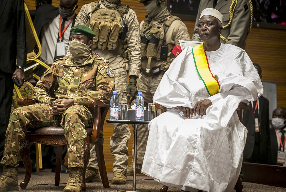 FILE- In this Friday, Sept. 25, 2020 file photo, retired Col. Maj. Bah N'Daw, right, is sworn into the office of transitional president, and Col. Assimi Goita, left, head of the junta that staged the Aug. 18 2020 coup, is sworn into the office of transitional vice president, at a ceremony in the capital Bamako, Mali. Mali's military has released the transitional president and prime minister Moctar Ouane from detention Thursday May 27, 2021, after they resigned from their respective posts.(AP Photo, File)