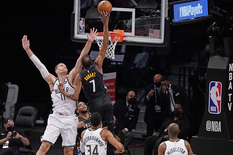 Milwaukee Bucks center Brook Lopez (11) tries to block Brooklyn Nets forward Kevin Durant (7) as Durant shoots during the first half of Game 2 of an NBA basketball second-round playoff series, Monday, June 7, 2021, in New York. (AP Photo/Kathy Willens)