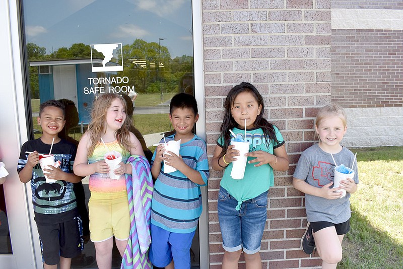 RACHEL DICKERSON/MCDONALD COUNTY PRESS Lamont Hinton, left, Lucy Bodine, Isaac Belland, Dileydy Tistoj and Avery Stites enjoy shave ice after a water day at Pineville Primary School during summer school on June 11, 2021.
