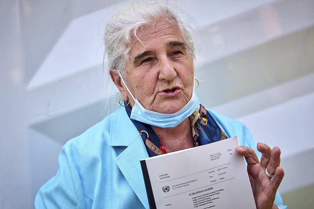 Munira Subasic of the Mothers of Srebenica activist group holds the verdict of the International Residual Mechanism for Criminal Tribunals dismissing Ratko Mladic's appeal, outside the court in The Hague, Netherlands, Tuesday, June 8, 2021. U.N. appeals judges on Tuesday upheld the conviction of former Bosnian Serb military chief Ratko Mladic for genocide and other offenses during Bosnia's 1992-95 war and confirmed his life sentence. (AP Photo/Phil Nijhuis)