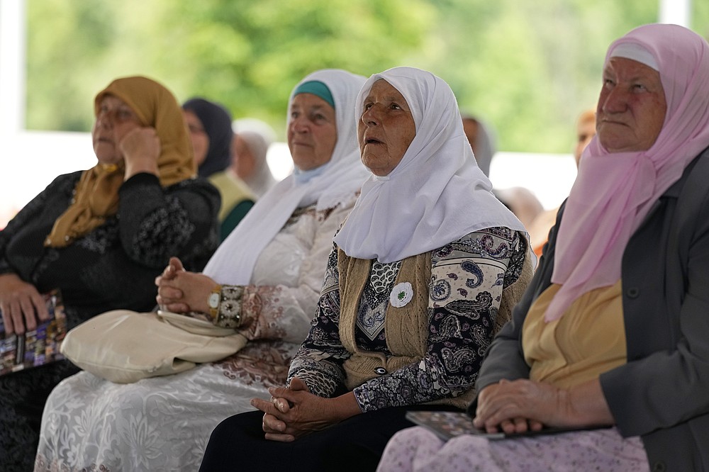 Women from Srebrenica wait to watch a live broadcast from the Yugoslav War Crimes Tribunal in The Hague and learn the verdict for Bosnian Serb military chief Ratko Mladic, at the memorial cemetery in Potocari near Srebrenica, eastern Bosnia, Tuesday, June 8, 2021. The United Nations court delivers its verdict in the appeal by former Bosnian Serb military chief Ratko Mladic against his convictions for genocide and other crimes and his life sentence for masterminding atrocities throughout the Bosnian war.(AP Photo/Darko Bandic)