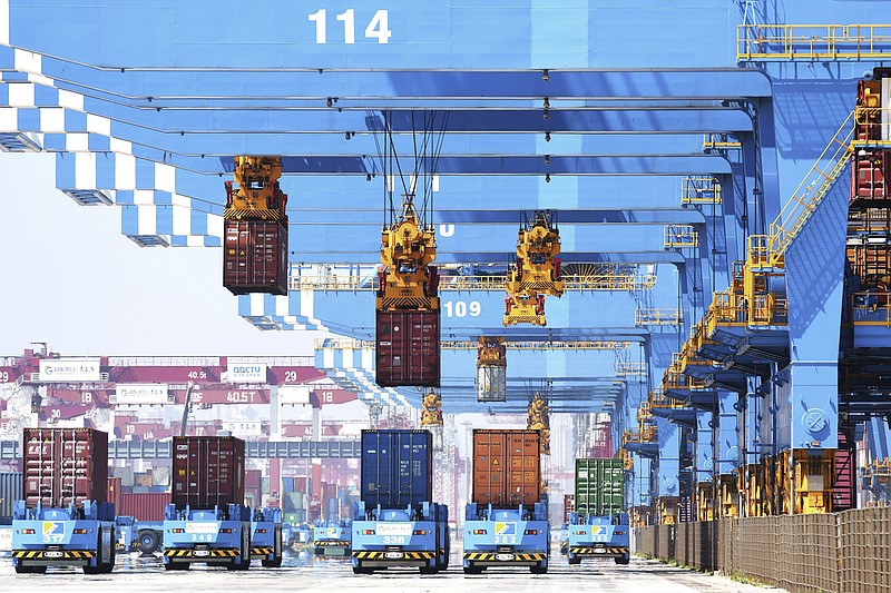 Gantry cranes move containers onto transporters at a port in Qingdao in eastern China's Shandong province Friday, June 4, 2021. China's exports surged nearly 28% in May while imports jumped 51% as demand rebounded in the U.S. and other markets where the pandemic is waning, though growth is leveling off after a stunning recovery from last year's slump. (Chinatopix via AP)