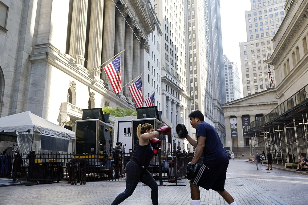 A woman and her trainer workout outside the New York Stock Exchange, Monday, June 7, 2021. Stocks are nudging mostly higher in early trading, putting the S&P 500 and the Dow Jones Industrial Average back near the record highs they reached a month ago. (AP Photo/Richard Drew)