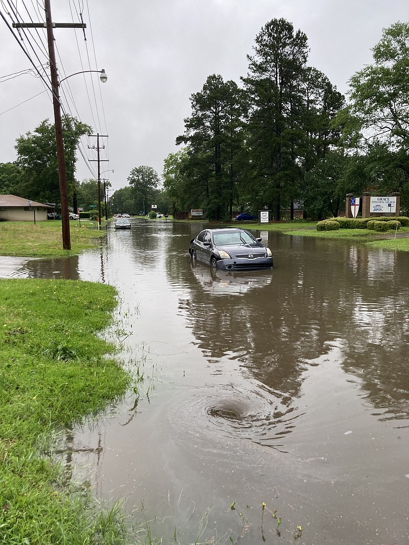 A few drivers who tried to make it down Hazel Street on Tuesday were unsuccessful as the high water was too much for their cars. The flooded street was slowing draining, as evidenced by the eddy that can be seen in the foreground. (Pine Bluff Commercial/Byron Tate)