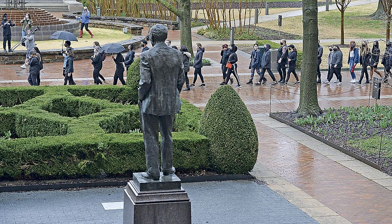 A large group of University of Arkansas students and members of the campus community march Saturday, March 13, 2021, past a statue of J. William Fulbright near Old Main during a rally on the university campus in Fayetteville. Student organizations hosted the anti-racism rally to express support for the campus to disassociate from Fulbright and Charles Brough, two historical figures who have been criticized for stances taken against civil rights and in support of white landowners after racial violence against Black citizens. Visit nwaonline.com/210314Daily/ for today's photo gallery. 
(NWA Democrat-Gazette/Andy Shupe)